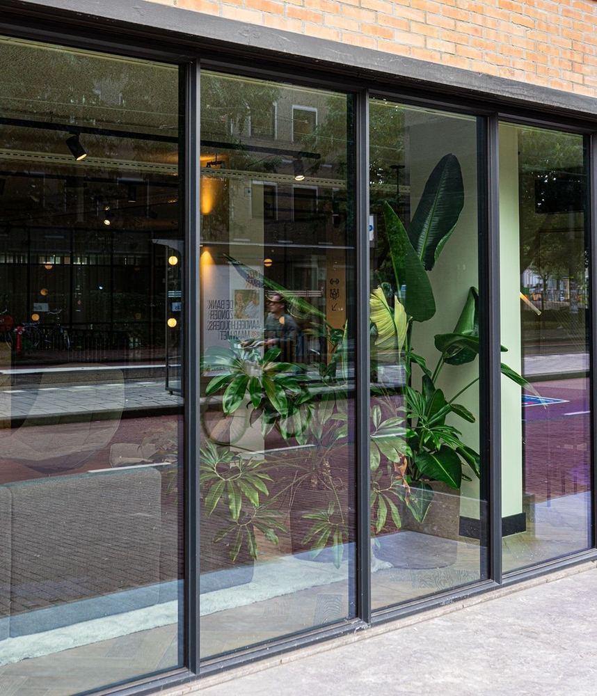 Moderne aluminium pui met grote glasvlakken in een eigentijdse gevel
