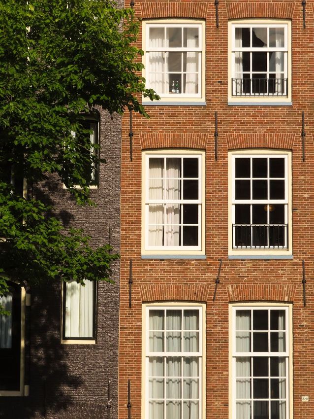 Klassieke Amsterdamse gevel met houten schuifvensters
