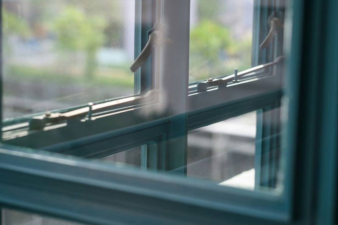 Detailopname van het hang- en sluitwerk en de beglazing van een kozijn