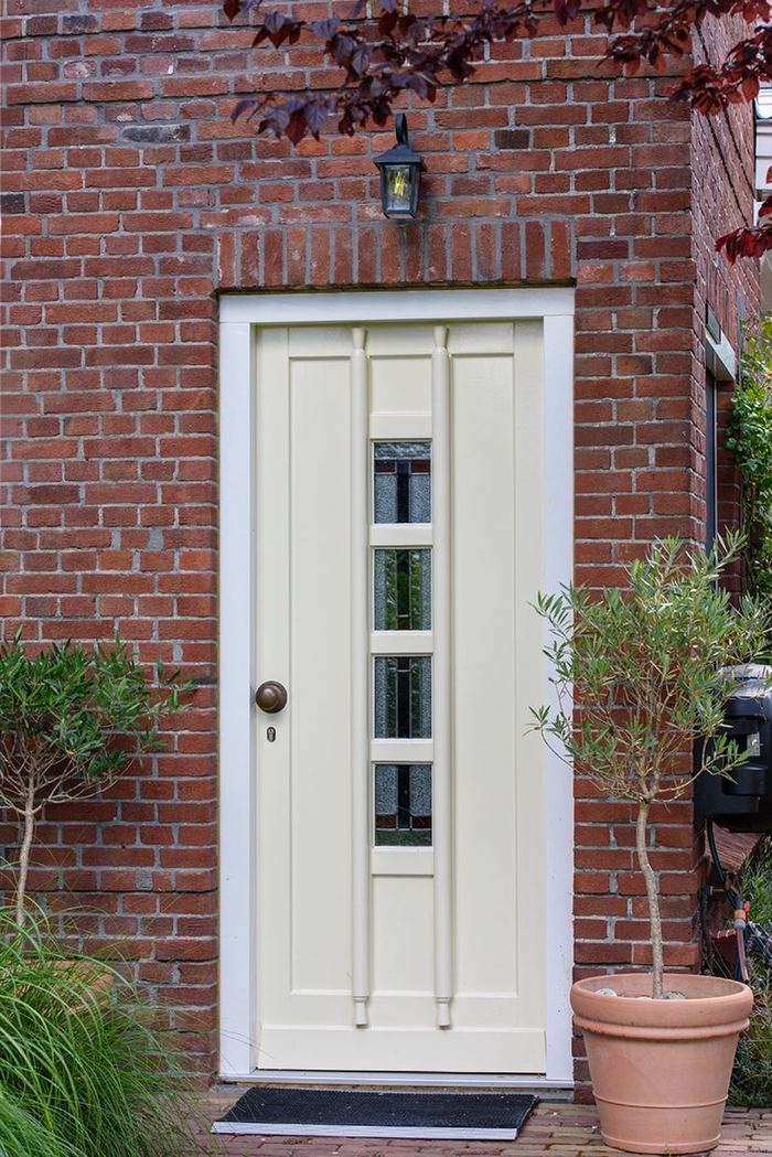 Klassieke houten voordeur in crèmekleur met glas-in-lood accenten