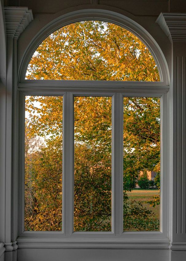 Klassiek houten kozijn met uitzicht op herfstbladeren